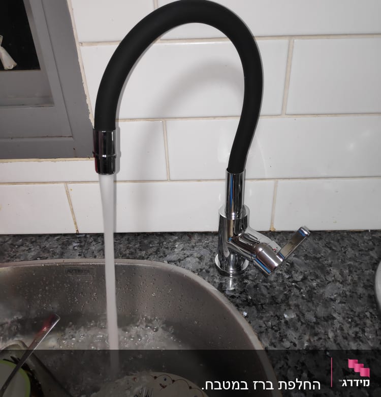 ברז מטבח עם מים זורמים לכיור